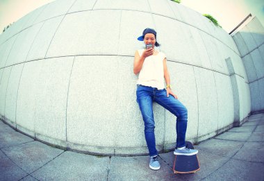 Cep telefonu kullanan genç kaykaycı