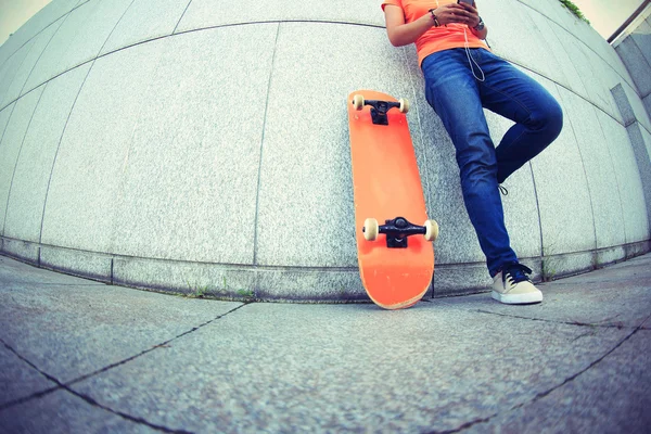 Jeune skateboarder utilisant un téléphone portable — Photo