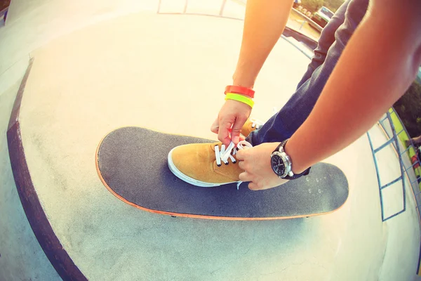 skateboarder tying shoelace