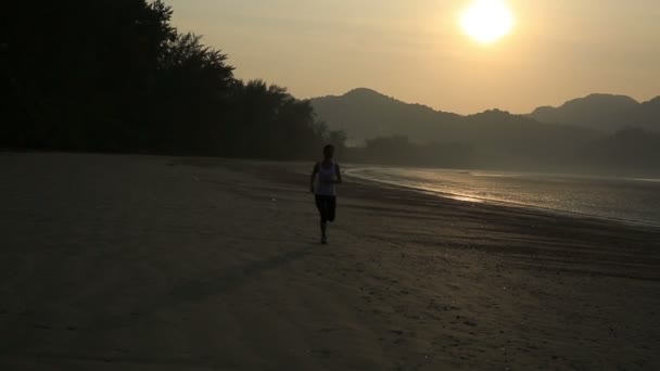Woman running at sunrise beach — Stock Video