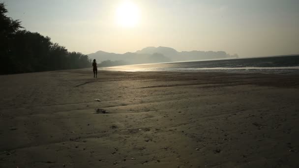 Woman running at sunrise beach — Stock Video