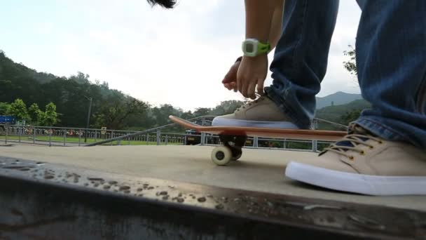 Skateboarder bindet Schnürsenkel — Stockvideo