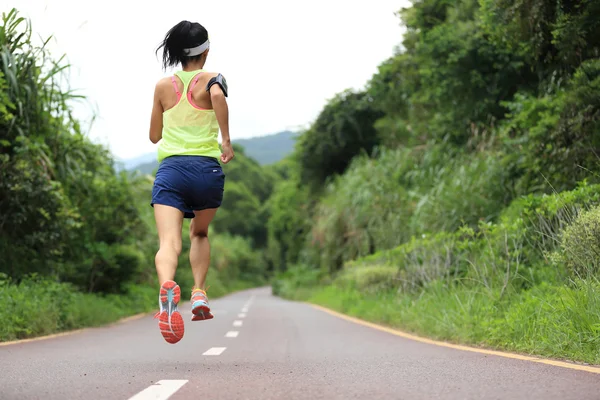 Female athlete running on forest trail — Stock Photo, Image