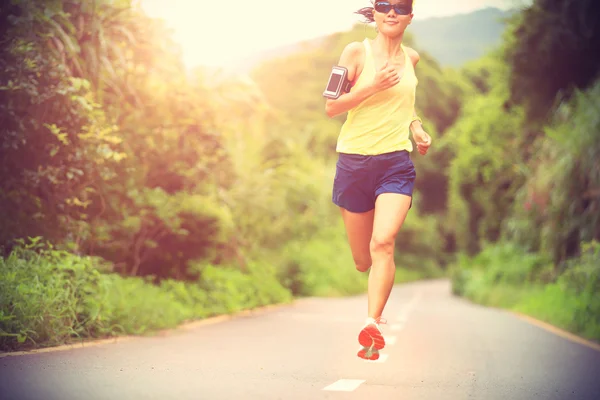 Atleta femenina corriendo por sendero forestal — Foto de Stock