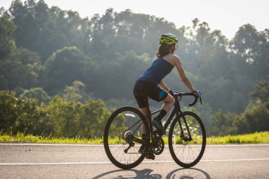 Yaz parkında bisiklet süren bir bisikletçi.
