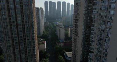 Gökyüzü manzarası düz bir şehir yoluna bakıyor. Yoğun, yüksek binalarla simetrik olarak çizilmiş..