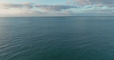 Ufuk çizgisine uzanan yumuşak yüzey dalgaları olan berrak mavi okyanus suları..