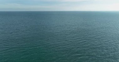 Ufuk çizgisine uzanan yumuşak yüzey dalgaları olan berrak mavi okyanus suları..