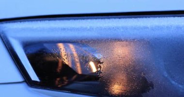 Işığı yansıtan ıslak arabanın farlarını kapat.