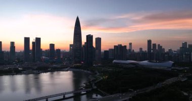 Gün doğumunda sisli, güneşli gökdelenler arasında uzanan geniş bir yol var..