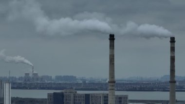 Gökyüzüne karşı endüstriyel bacadan yükselen duman