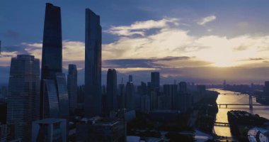 Gündoğumunda ya da günbatımında modern gökdelenlerin hakim olduğu dramatik şehir silüeti. .