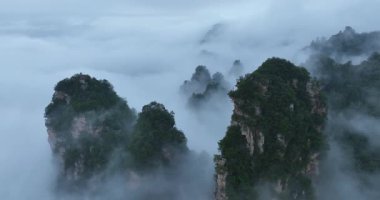 Pürüzlü dağ zirveleri yoğun, ürkütücü bir alçak asılı bulut tabakasından ya da sisten ortaya çıkar. 