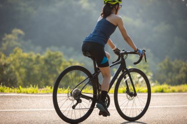 Yaz parkında bisiklet süren bir bisikletçi.