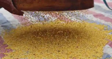 Parlak sarı baharat tozu yutan eller ya da ahşap tepside yeşil yapraklı aperatifler.