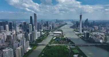 Guangzhou 'nun Canton Kulesi de dahil olmak üzere modern silueti, önünde yeşil bir ada bulunan geniş Pearl Nehri ile ayrılmıştır..