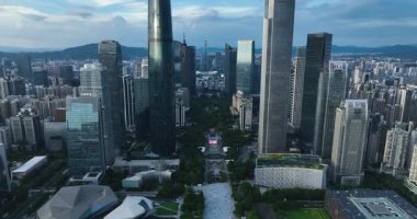 Işıl ışıl bir günde, iki uzun cam gökdelen arasındaki yoğun şehir manzarası.