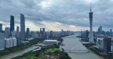 Guangzhou 'nun Canton Kulesi de dahil olmak üzere modern silueti bulutlu bir gökyüzünün altında İnci Nehri ile sınırdır..