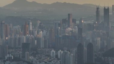 Yüksek gökdelenlerin hakim olduğu devasa bir modern şehrin puslu hava manzarası..