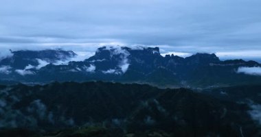 Uçsuz bucaksız beyaz bulutlar ve sis bulutu uzak zirveleri olan dağları kaplıyor..
