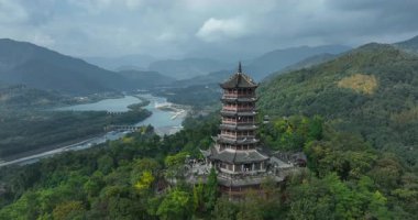 Sarmal nehre ve sisli dağlara bakan antik pagoda.