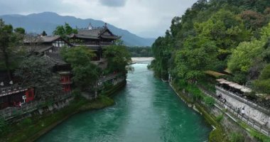 Yeşil ağaçlar ve binalar arasında akan nehir