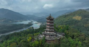Sarmal nehre ve sisli dağlara bakan antik pagoda.