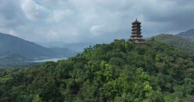 Sarmal nehre ve sisli dağlara bakan antik pagoda.