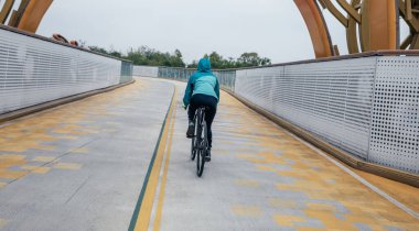 Bisiklete binen kadının arka manzarası.