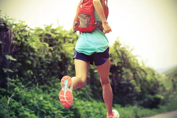 Atleta feminino correndo em trilha florestal — Fotografia de Stock