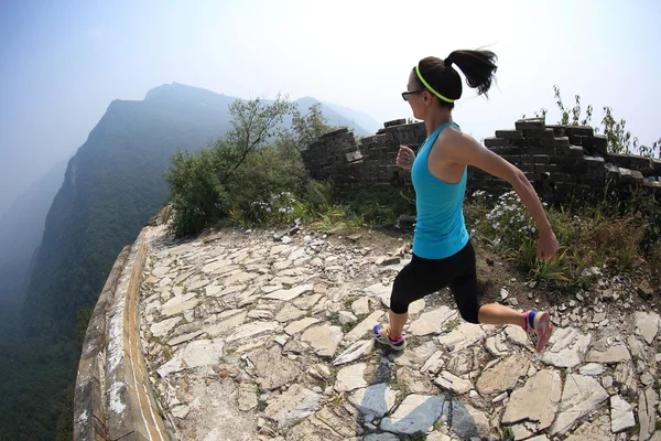 Piernas femeninas corriendo en chino gran pared — Foto de Stock