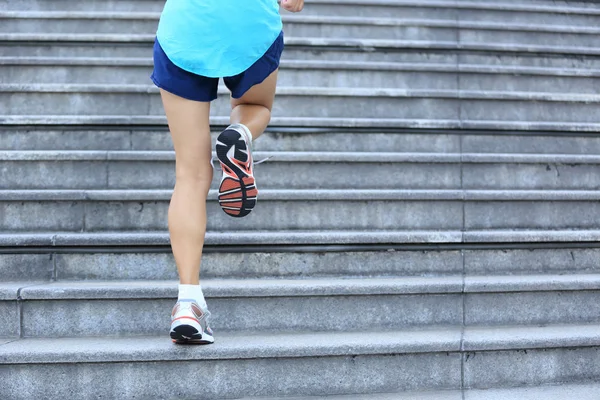 Jambes féminines courant dans les escaliers — Photo