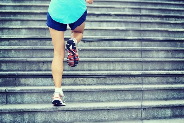 Jambes féminines courant dans les escaliers — Photo