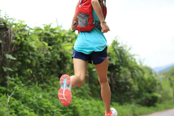 Atleta femenina corriendo por sendero forestal — Foto de Stock
