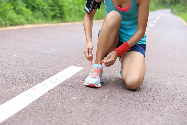 Sportliche Läuferin bindet Schnürsenkel — Stockfoto