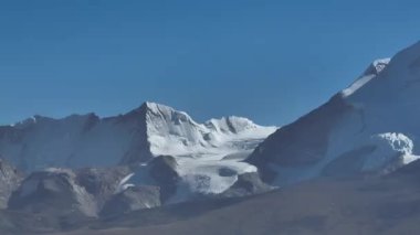 Karlı dağ zirveleri berrak mavi gökyüzünün altında