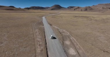 Yüksek irtifada göl kenarında çalışan off-road aracının hava görüntüleri.