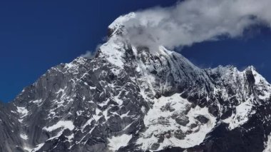 Mavi gökyüzünün altındaki karlı dağ zirvesi