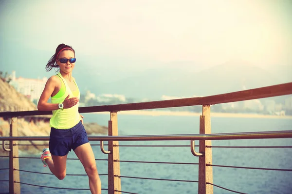 Sporty woman running on boardwalk — Stock Photo, Image