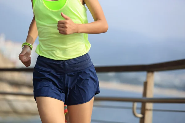 Sportiga kvinnan körs på strandpromenaden — Stockfoto