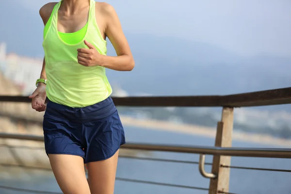 Sporty woman running on boardwalk — Stock Photo, Image