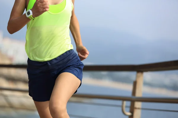 Sporty woman running on boardwalk — Stock Photo, Image