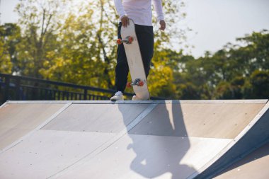 cropped shot of skateboarder skateboarding at skatepark in city