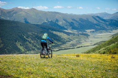 Güzel dağlarda bisiklet süren bir kadın