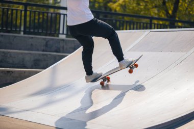 cropped shot of skateboarder skateboarding at skatepark in city