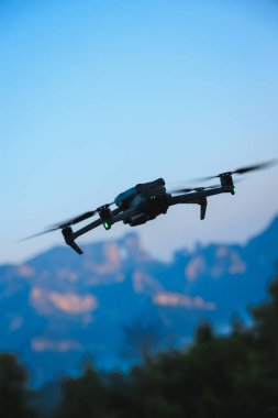 Modern insansız hava aracı dağların tepesinde uçuyor.