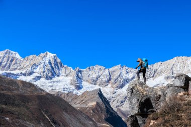 Başarılı kadın yürüyüşçü yüksek rakımlı dağın tepesine tırmanıyor.