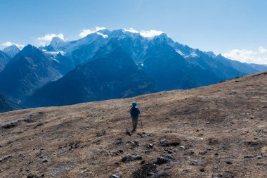 Sırt çantalı bir kadın yüksek irtifada dağ yürüyüşü yapıyor.