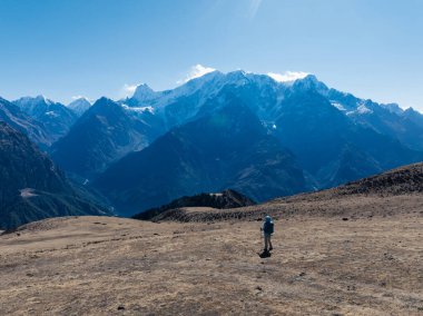 Sırt çantalı bir kadın yüksek irtifada dağ yürüyüşü yapıyor.