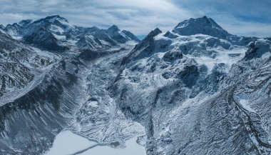 Güzel yüksek irtifa buzulu ve kar kaplı dağlarla Tibet, Çin 'de donmuş göl